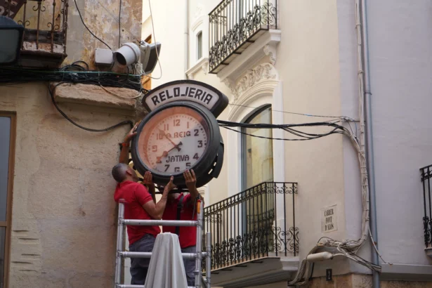 Operaris instal·len el rellotge a Xàtiva.