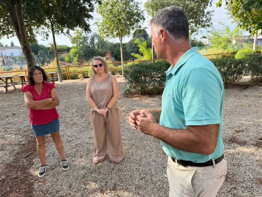 Tres personas conversan en una zona arbolada de la urbanización El Pantano, en Torrent