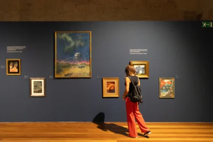 Visitante ante obras de José Segrelles en la exposición del Centre del Carme de València