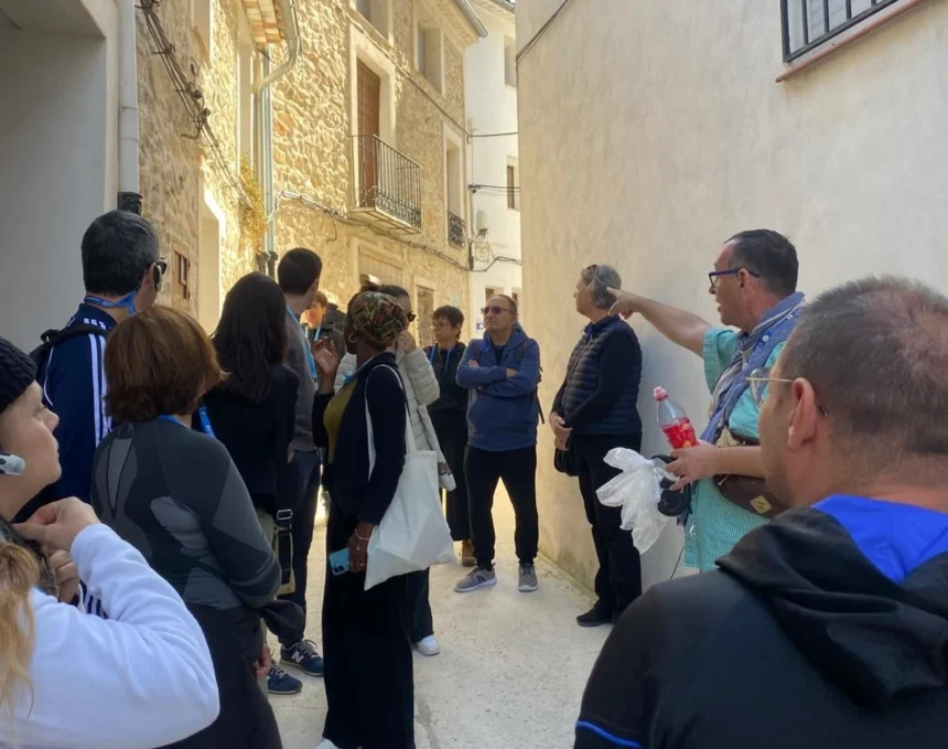 Grupo de personas escucha a un guía en una calle estrecha de Alpatró durante una visita guiada