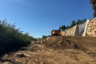 Excavadora junto a un muro de escollera en las obras del barranco de Picassent