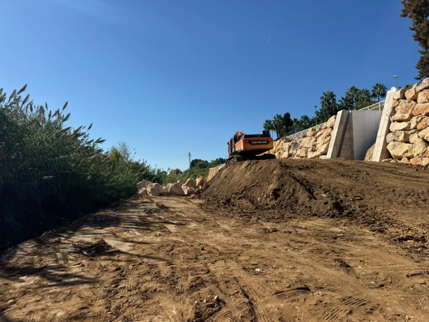 Excavadora junto a un muro de escollera en las obras del barranco de Picassent