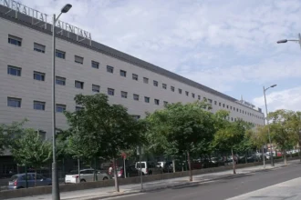 Fachada del edificio del Hospital de Manises, sede del departamento de salud, con árboles en la acera