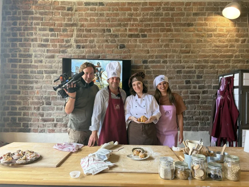 Equip de Valencians al món gravant en una cuina de Polònia amb diverses persones amb gorra de cuiner