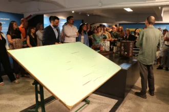 Visitants davant d'un tauler de dibuix antic durant la inauguració del Museu Industrial del Port de Sagunt