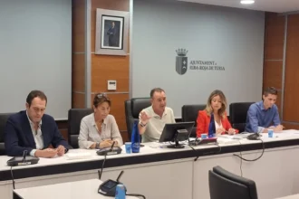 Cinco representantes municipales sentados en la mesa de la sala de plenos del Ayuntamiento de Riba-roja de Túria durante la asamblea