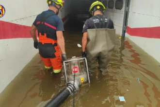 Bomberos achican agua de un garaje inundado.