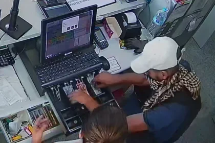 Fotograma de una cámara de seguridad en el que se ve a un hombre con gorra junto a la caja de una gasolinera