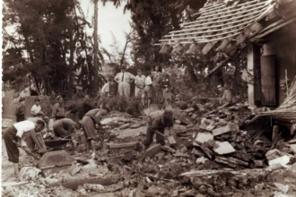 Fotografía antigua en sepia de varias personas retirando escombros de una casa derrumbada tras la riada de 1949 en Bétera