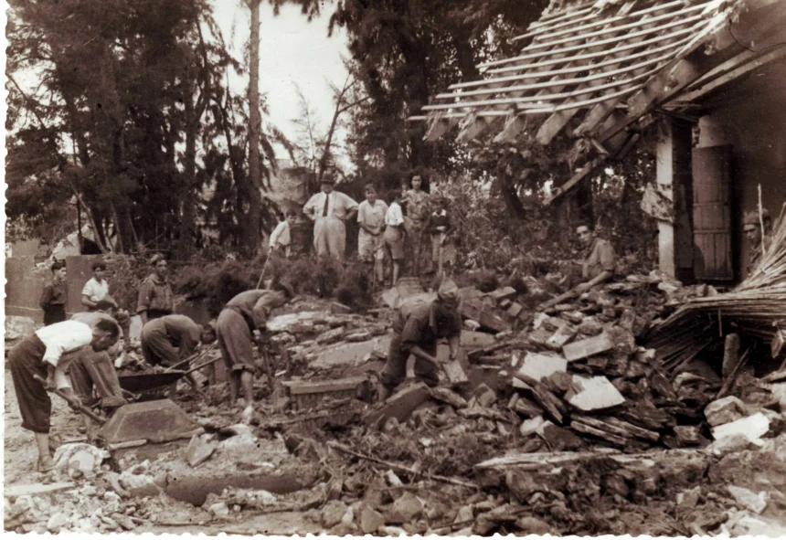 Fotografía antigua en sepia de varias personas retirando escombros de una casa derrumbada tras la riada de 1949 en Bétera