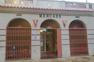 Fachada del mercado municipal de Alfafar, un edificio de 1952 con tres arcos y rejas metálicas