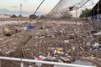 Estado del campo de fútbol El Palleter de Paiporta tras la dana de 2024, con la valla y el césped cubiertos de restos